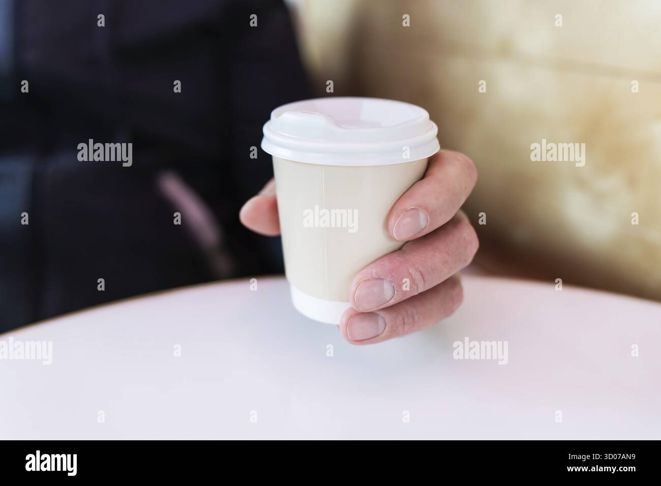 Tazza di caffè di carta in una mano maschio. Caffè da andare. Passeggiate all'aria aperta Foto Stock