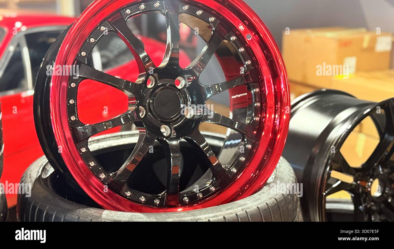 Cerchi personalizzati in lega nera e rossa per auto sportive in esposizione. Dettagli su cerchi e pneumatici in alluminio di alta qualità per autoveicoli. Concept di accessori e sintonizzazione di auto di lusso - Immagine stock catturata con smartphone