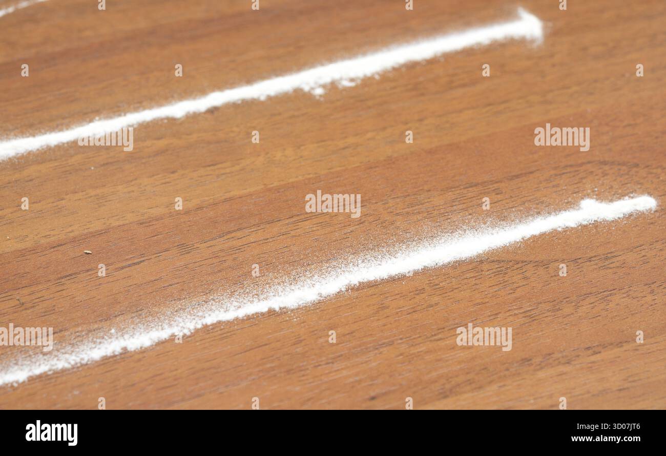 Strisce di cocaina su un tavolo di legno Foto Stock