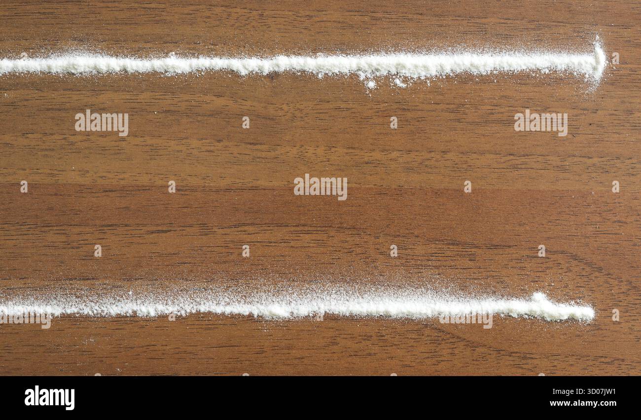 Strisce di cocaina su un tavolo di legno Foto Stock