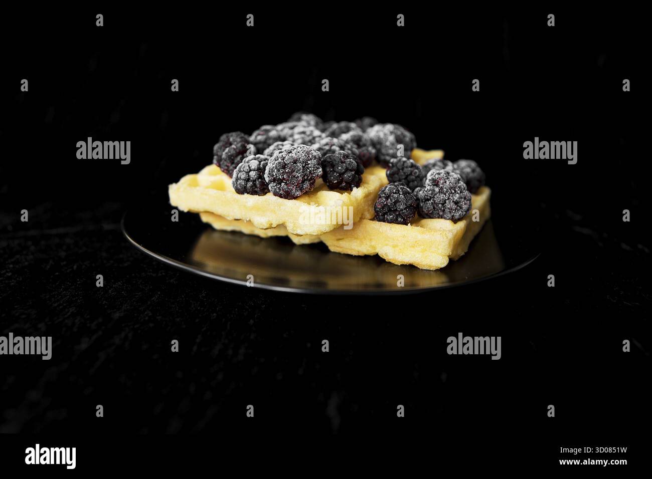 Cialde belghe con congelati more su sfondo nero Foto Stock