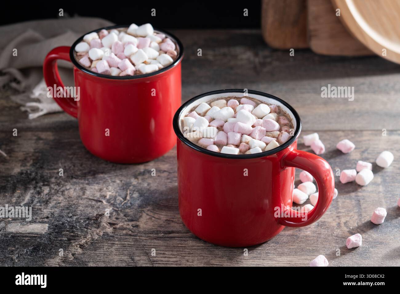 Bevanda calda a base di cioccolata con marshmallow in tazza rossa su un tavolo di legno Foto Stock
