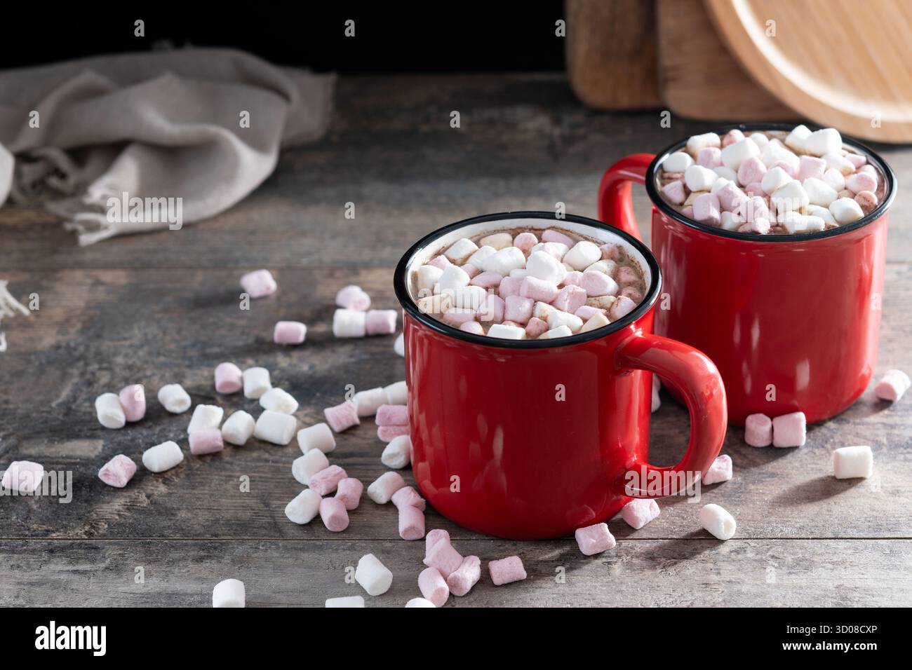 Bevanda calda a base di cioccolata con marshmallow in tazza rossa su un tavolo di legno Foto Stock