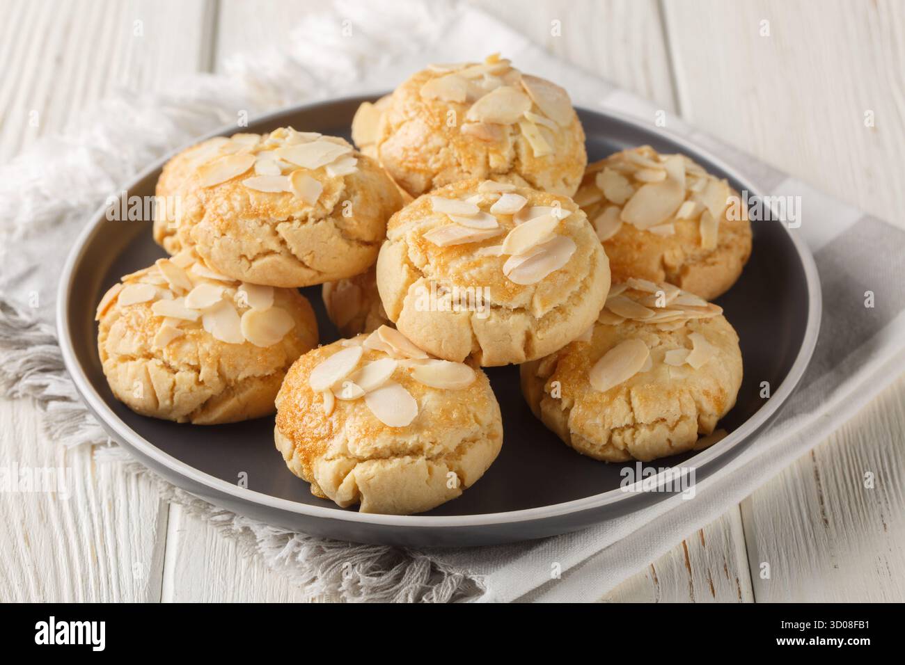Biscotti alle mandorle con cracker biologici, senza glutine e senza lattosio, primo piano in un piatto su un tavolo di legno. Orizzontale Foto Stock