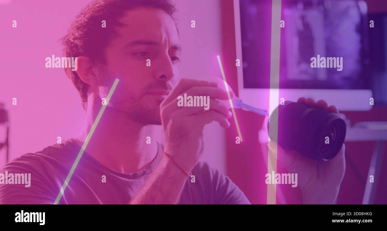 Tecnico della fotocamera che ripara l'obiettivo in uno studio con illuminazione al neon, con cacciavite, spazio di copia Foto Stock