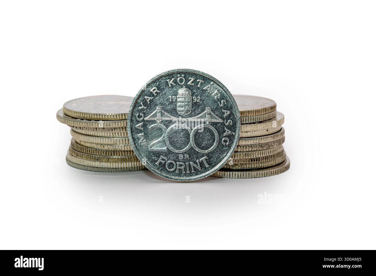 La vecchia moneta ungherese d'argento del 200 Forint del 0,500 si erge accanto ad altre monete impilate in una pila; fotografata con sfondo bianco e stretta profondità di campo Foto Stock