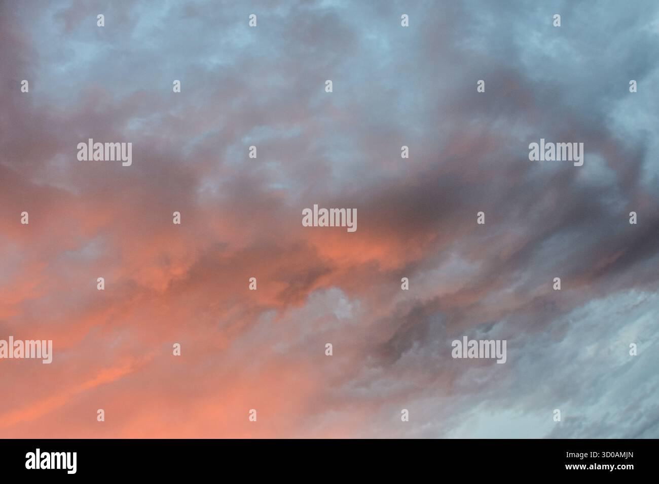 I caldi colori pastello si fondono splendidamente in tutto il cielo, mentre la luce del tramonto si illumina dolcemente attraverso delicate nuvole, creando un'atmosfera tranquilla. Foto Stock