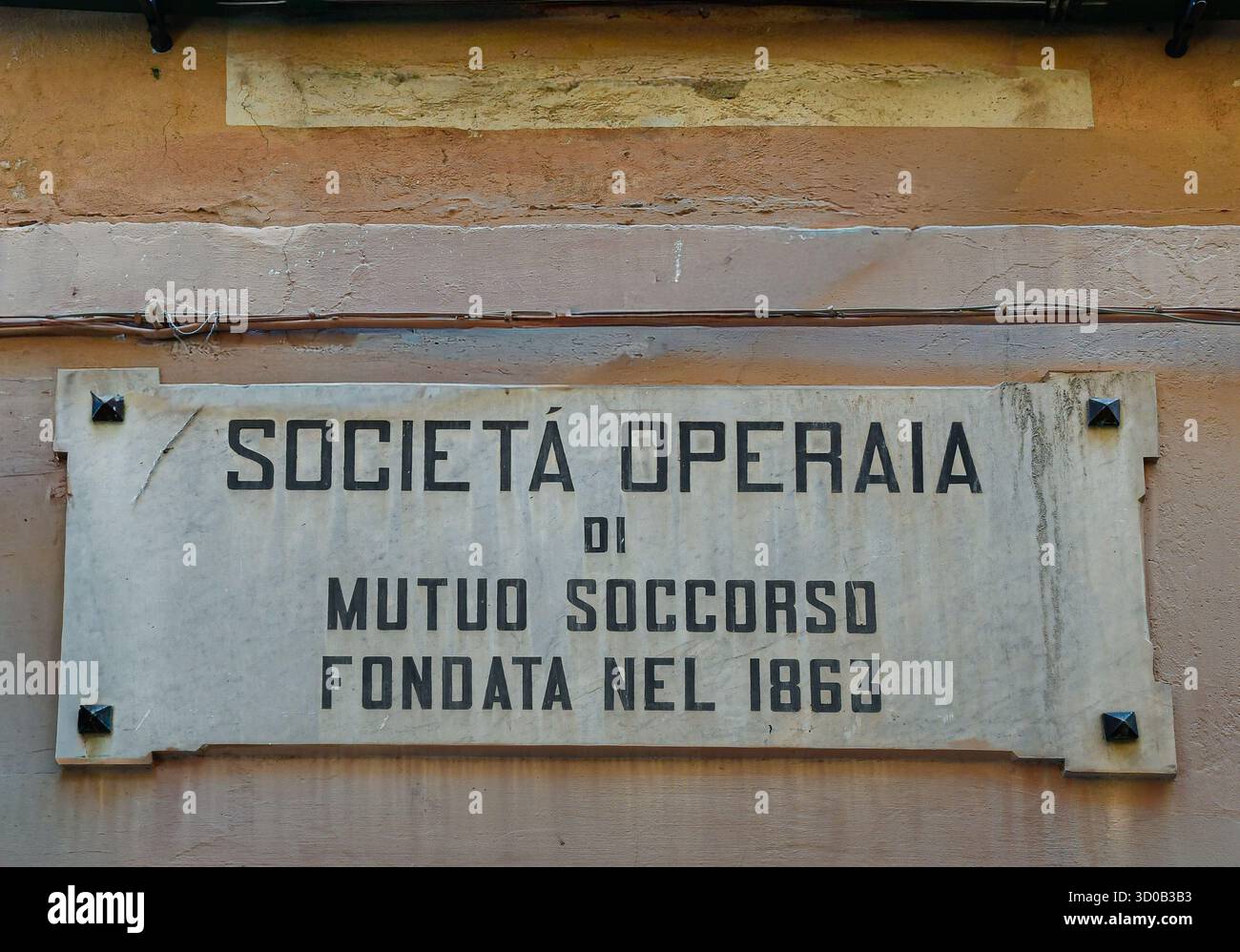 Primo piano del cartello marmoreo della Società Operai di mutuo soccorso - società di mutuo soccorso operaio - nel centro storico di Alassio (Savona), Liguria, Italia Foto Stock