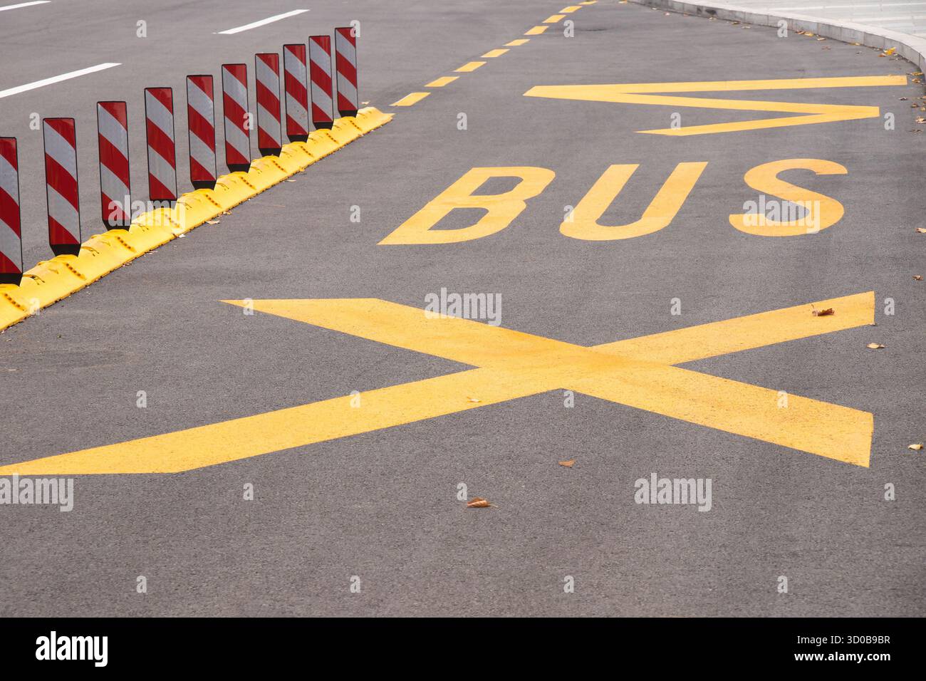 Segnaletica stradale gialla alla fermata dell'autobus e divisori di corsia fluorescenti di sicurezza su strade vuote della città Foto Stock