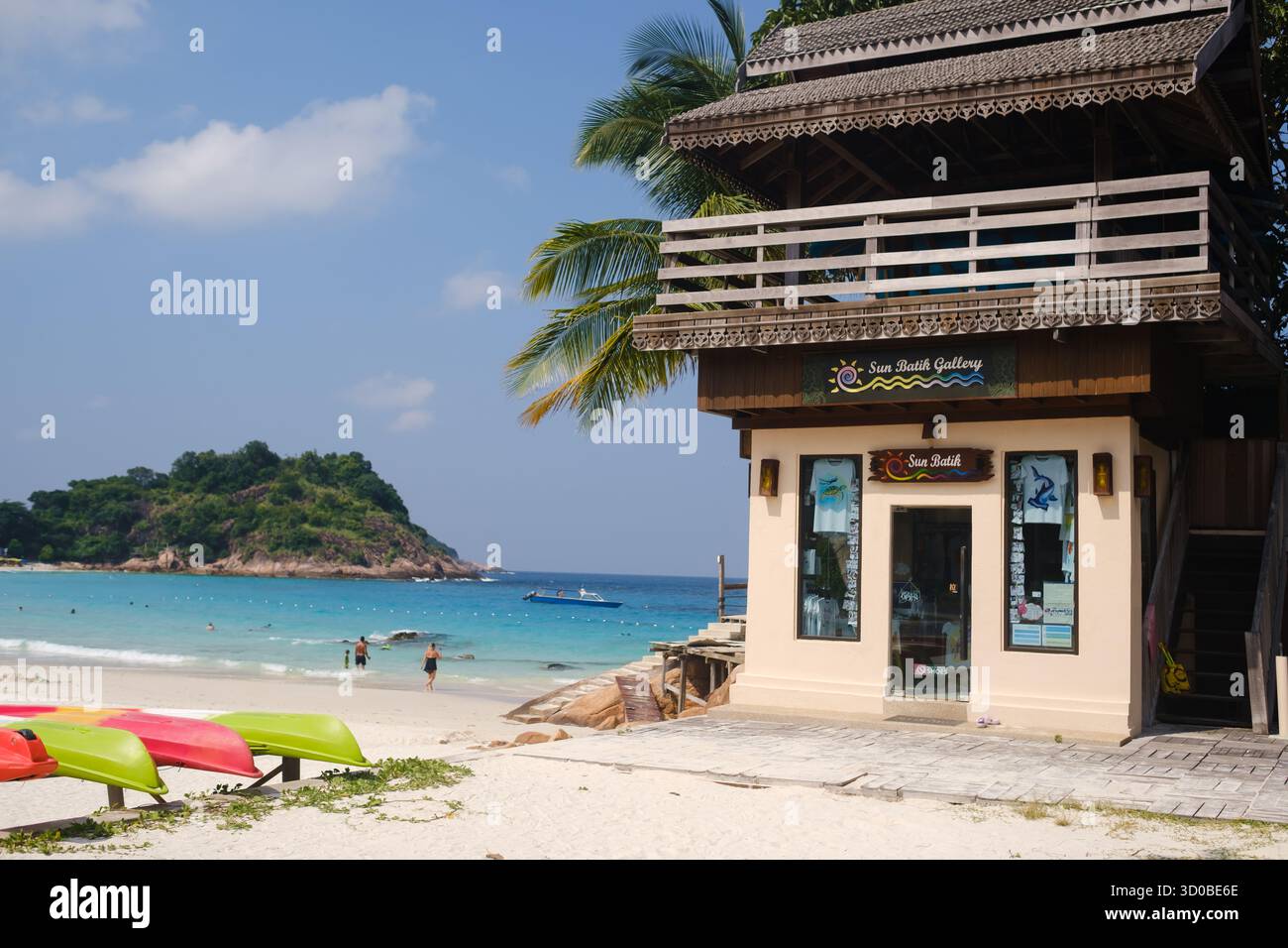 Isola di Redang. Malesia. 29 luglio 2025. Un edificio colorato e una lunga spiaggia con posti a sedere all'aperto in una luminosa giornata di sole. Foto Stock