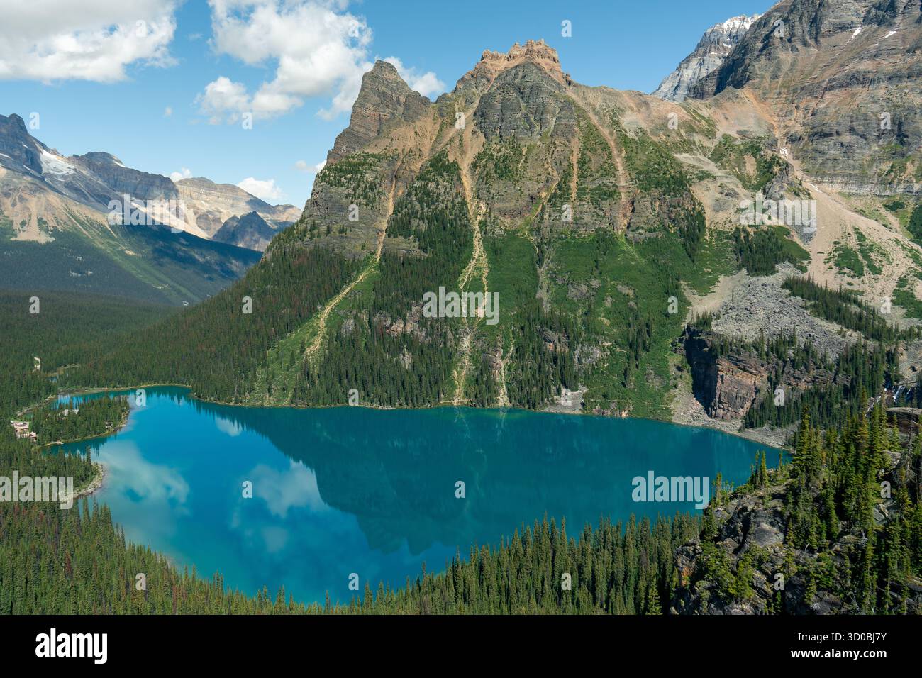 Un tranquillo lago turchese annidato sotto aspre montagne e lussureggianti foreste. Lago Ohara, British Columbia Foto Stock