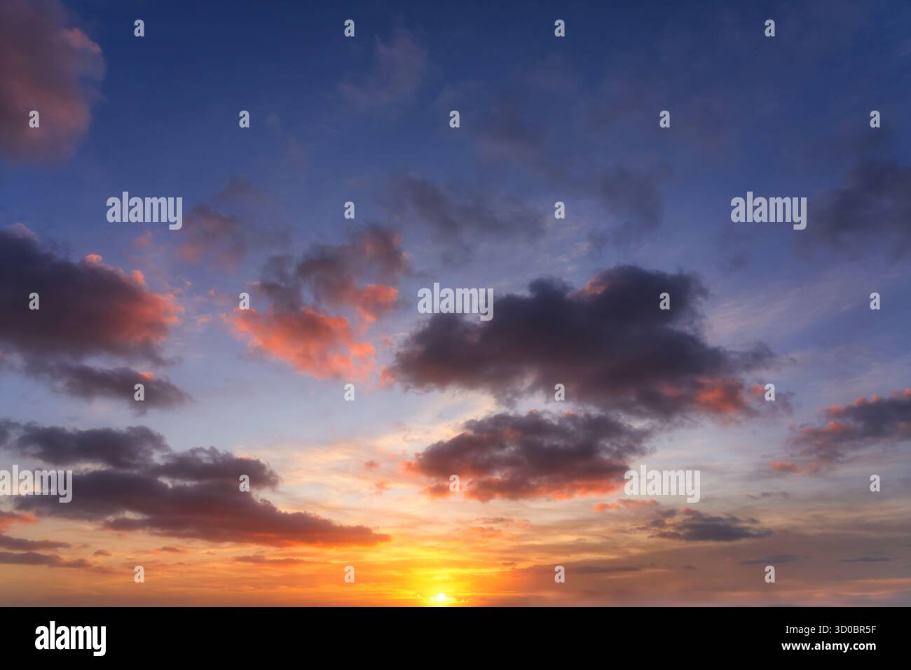 Sfondo fotografico ad alta risoluzione di un cielo spettacolare al tramonto. Colori vivaci: Nuvole blu intenso, viola e arancione ardente e rosse vicino all'orizzonte Foto Stock