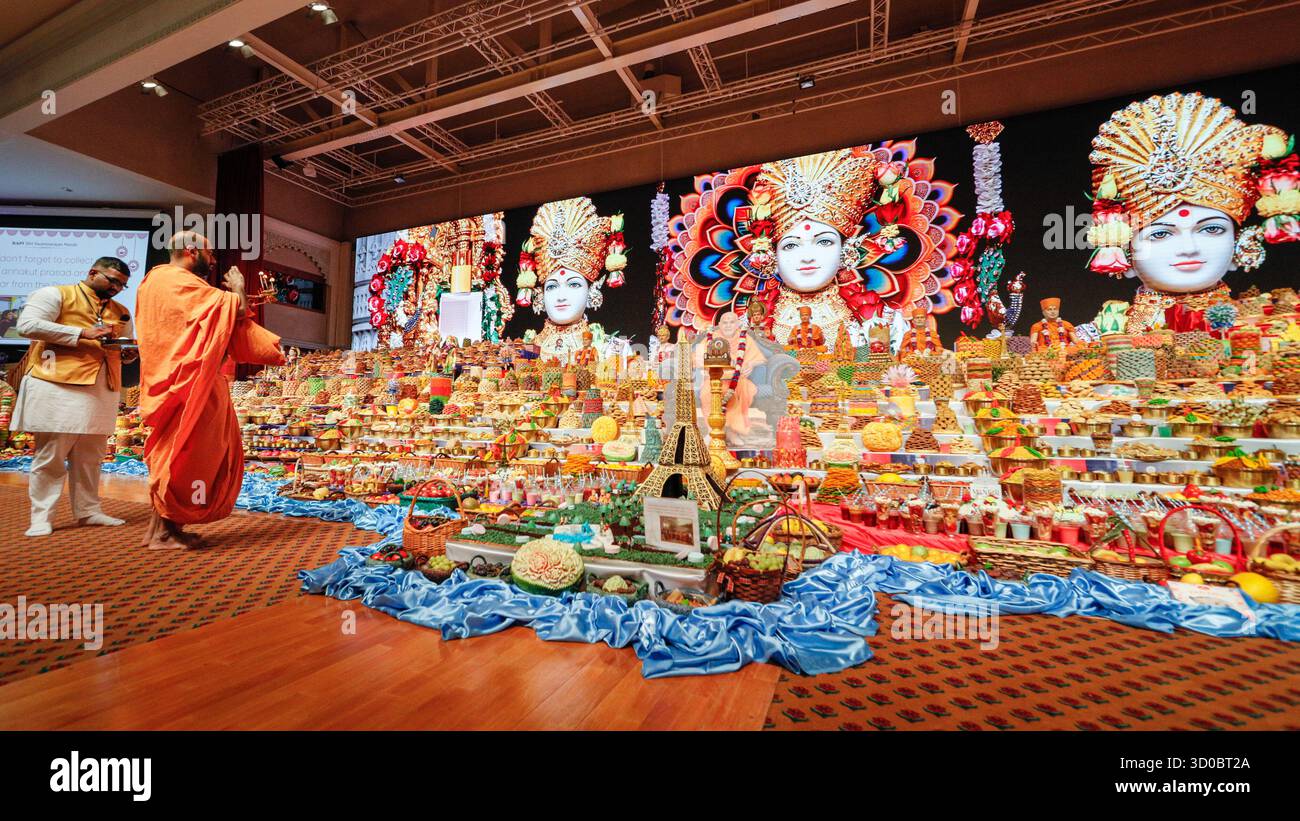 Londra, Regno Unito. 22 ottobre 2025. Un swami (sacerdote) esegue un rituale di candela davanti ai gradini, che sono stati riempiti di offerte di cibo. BAPS Shri Swaminarayan Mandir a Londra, popolarmente conosciuto come Neasden Temple, celebra il nuovo anno indù (ambientato in diversi periodi dell'anno in altri filoni dell'induismo). I festeggiamenti proseguono da Diwali, che è stata celebrata due giorni fa. Crediti: Imageplotter/Alamy Live News Foto Stock