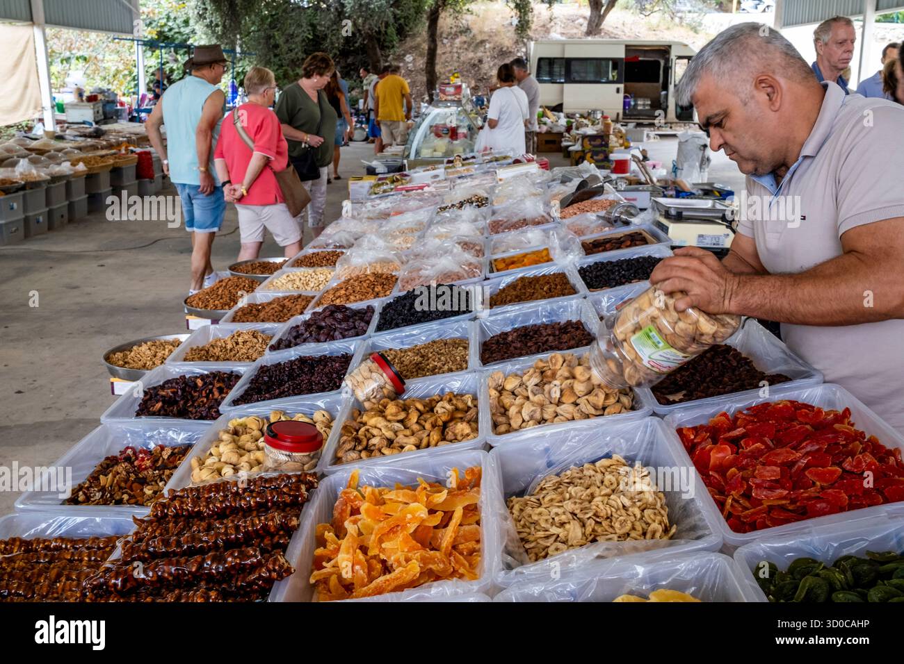 Un uomo locale organizza la sua frutta secca e noci al mercato del lunedì nella città di Turunc, provincia di Mugla, Turchia. Foto Stock
