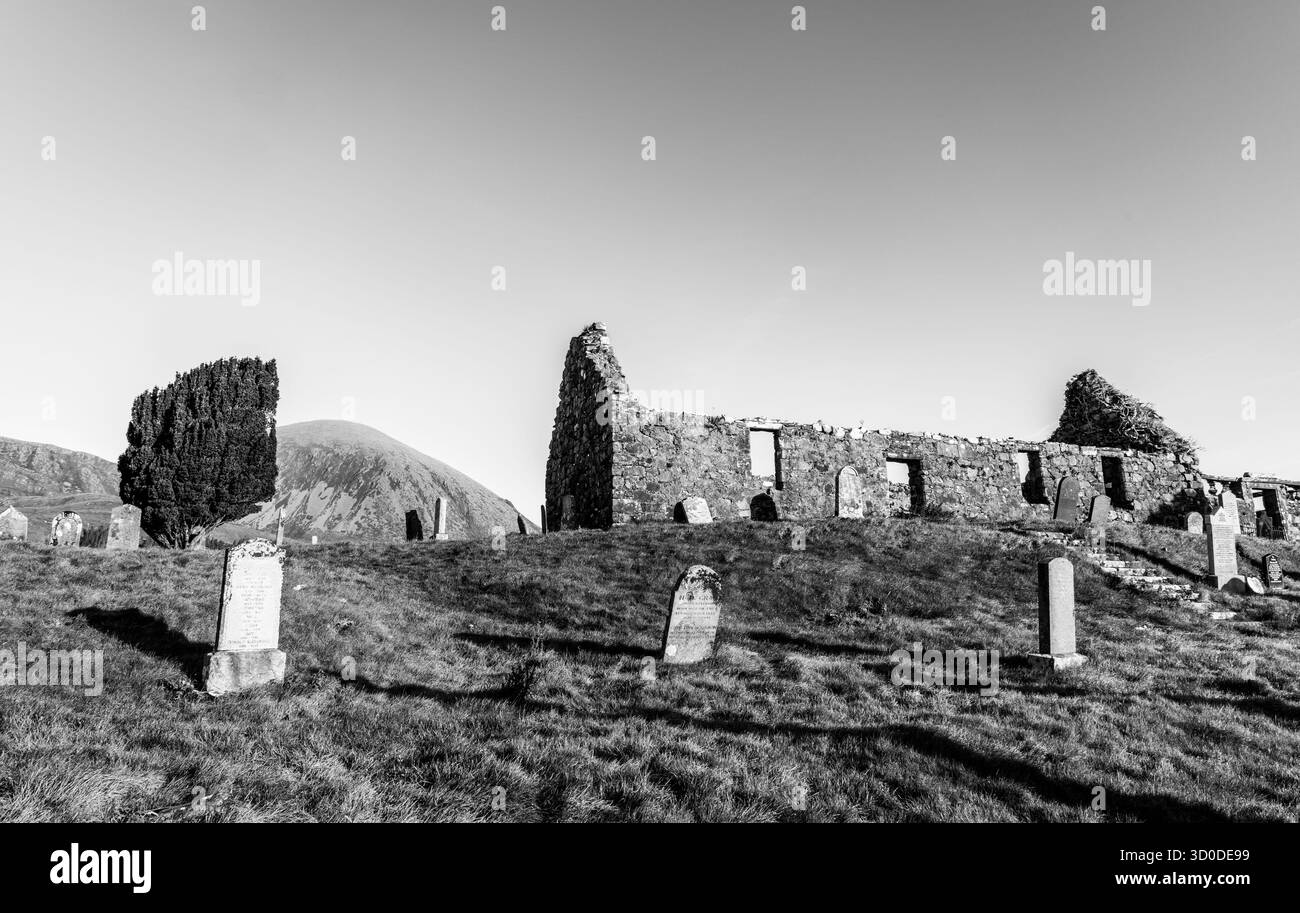 Immagine in bianco e nero della chiesa in rovina di Cill Chriosd con le tombe circostanti e le colline lontane Foto Stock