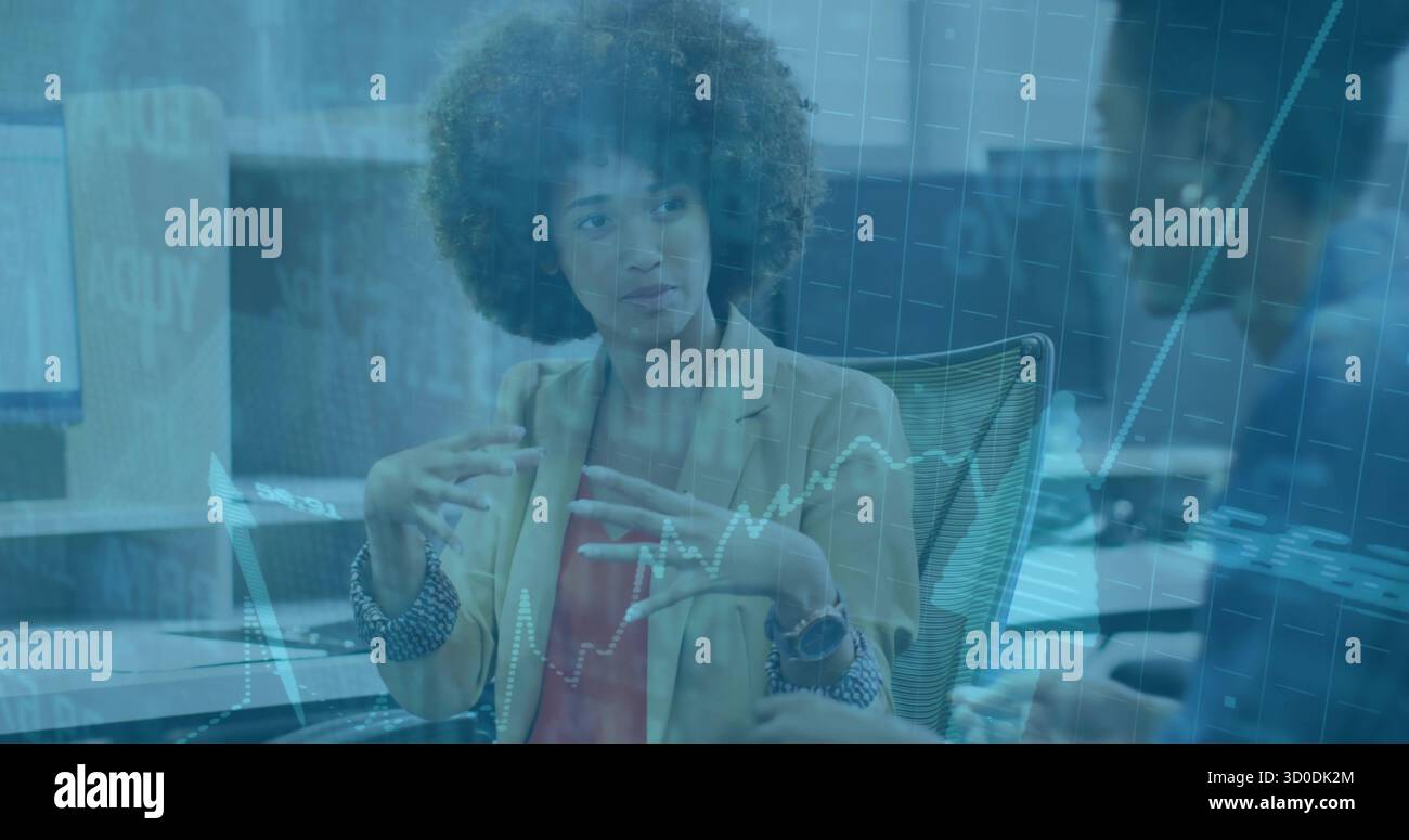 Gesti dei colleghi e spiegazioni delle tendenze in ufficio, con monitor, tastiera, mouse e grafici Foto Stock