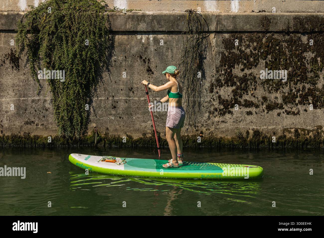 Lubiana, Slovenia agosto 10-2025 donne pagaiano in solitaria sul fiume ljubljanica Foto Stock