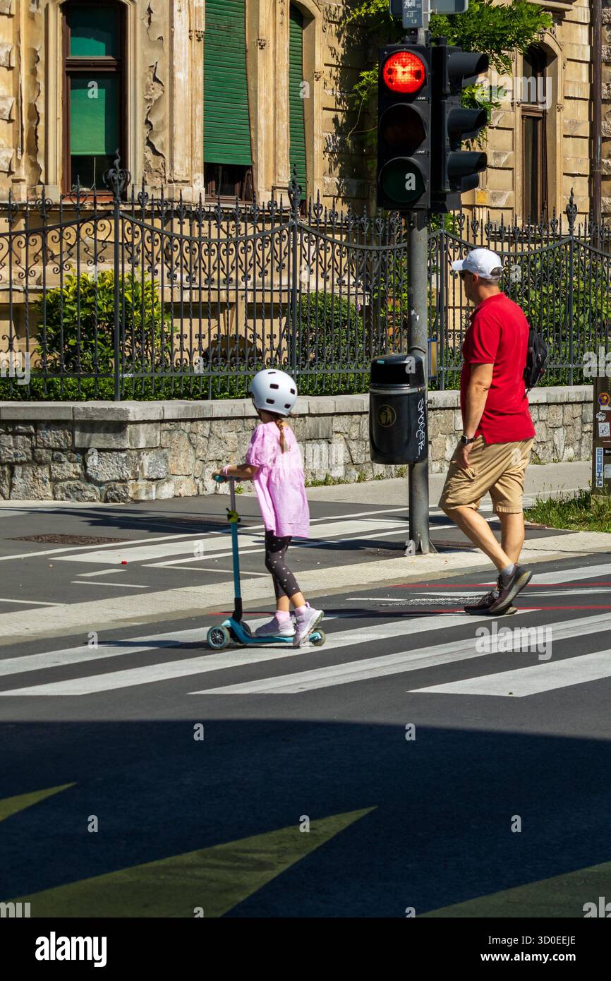 Lubiana, Slovenia agosto 10-2025 attraversamento pedonale con adulti e bambini , attraversamento pedonale con semaforo rosso Foto Stock