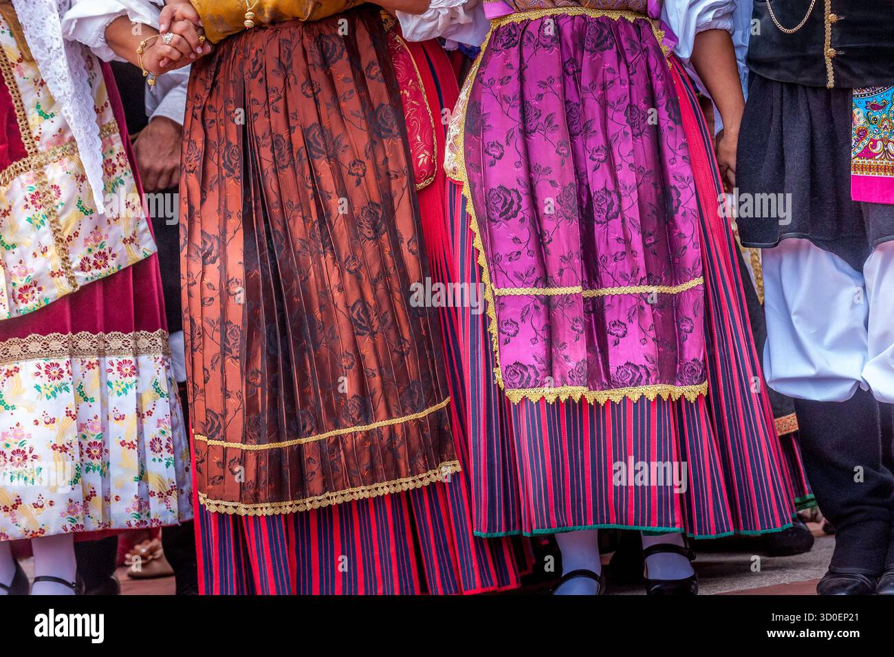 Dettaglio di costumi tradizionali sardi colorati con gonne e grembiuli ricamati, Sardegna, Italia Foto Stock