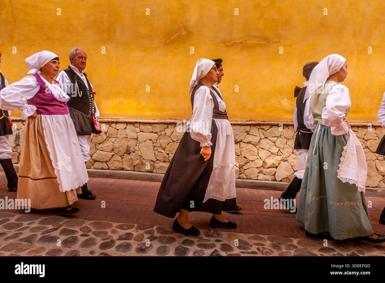 Musicista che suona una fisarmonica tradizionale durante una sfilata folcloristica sarda ad Assemini, in Italia, su un vivace sfondo giallo Foto Stock