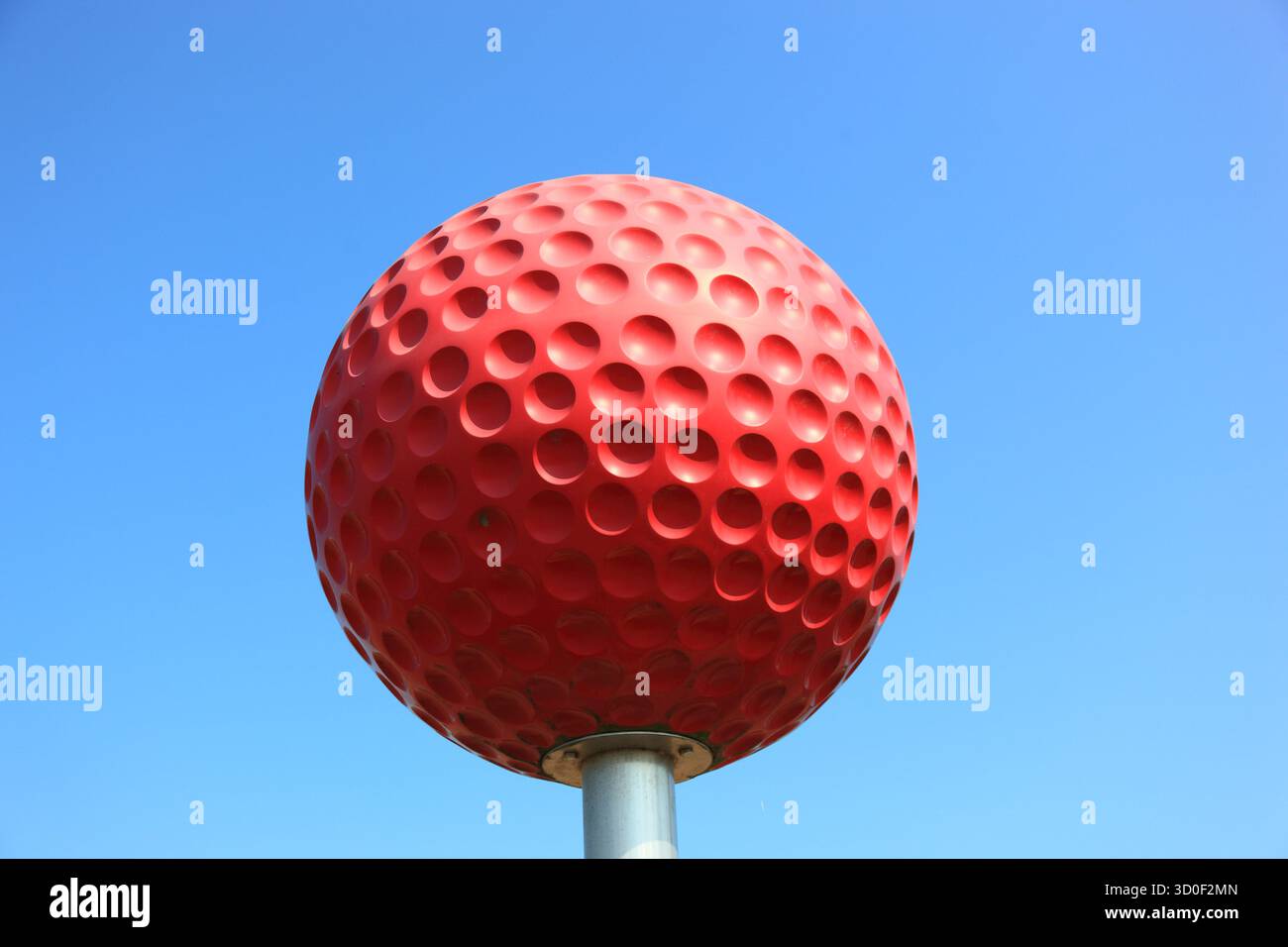 Grande pallina da golf rossa che pubblicizza un campo da golf Foto Stock