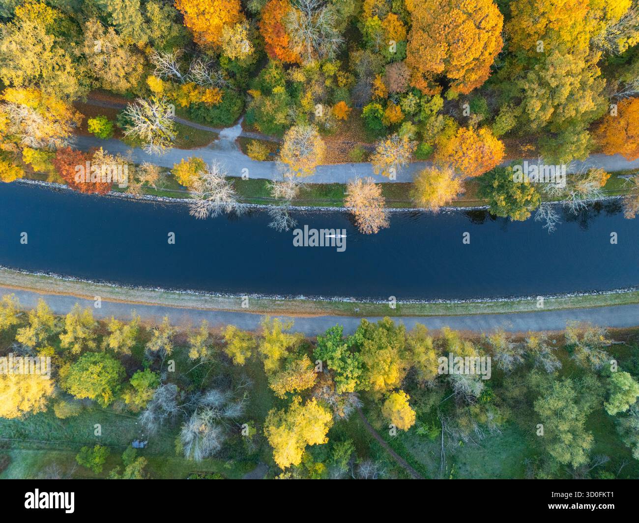 Vista aerea di un tranquillo corso d'acqua che attraversa un vivace arazzo di foglie autunnali, con sentieri su entrambi i lati, Stoccolma, Contea di Stoccolma, Svezia. Foto Stock