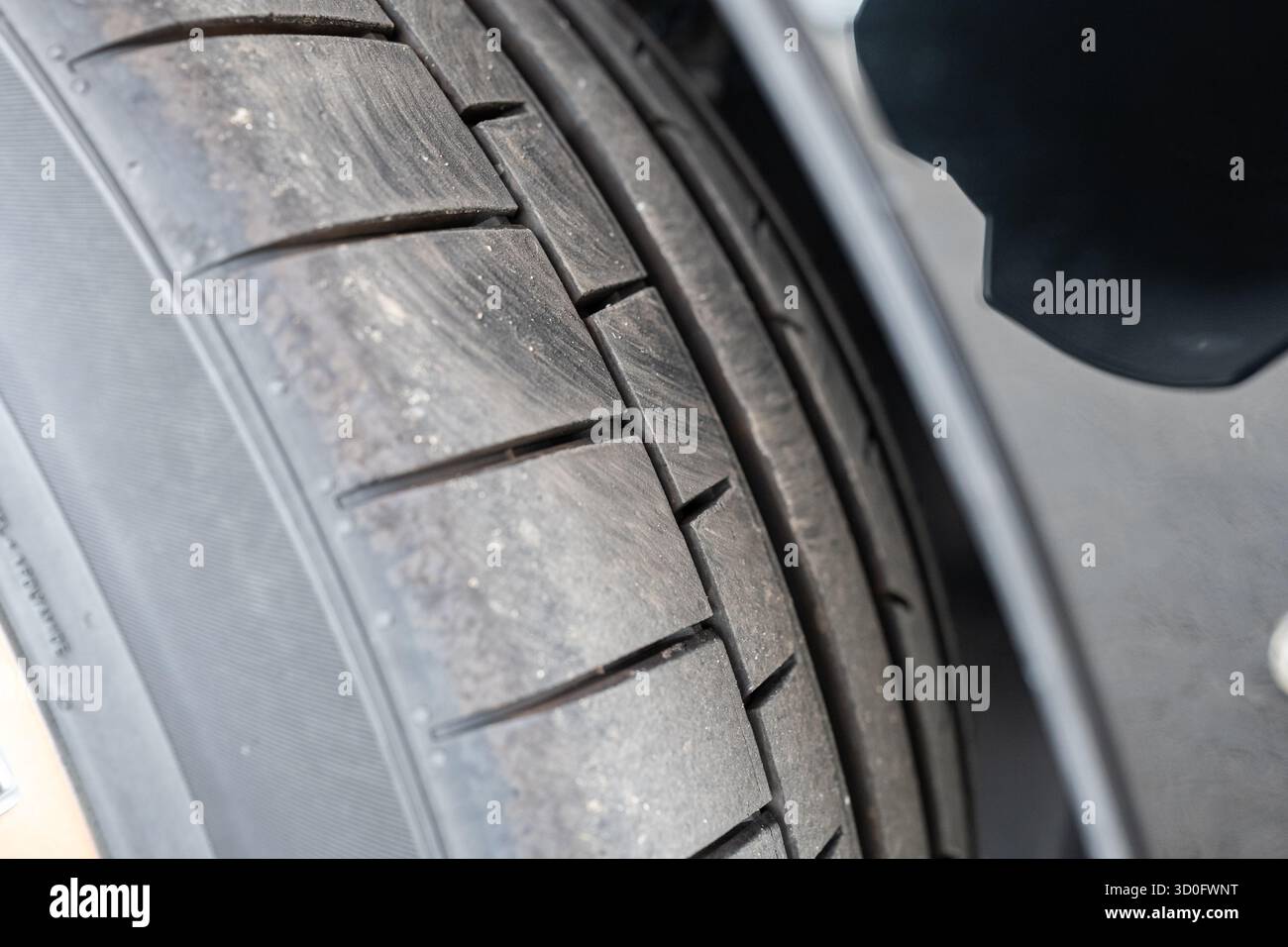 Profilo pneumatico e filettatura nuovi per auto. Basso, primo piano al livello del suolo, foto di dettaglio, niente persone Foto Stock