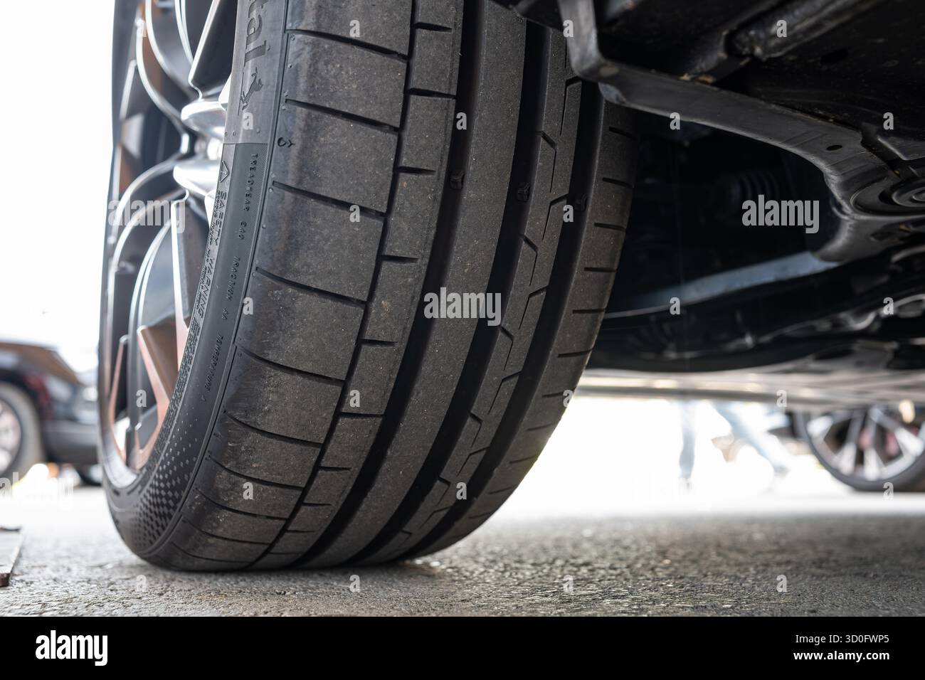 Profilo pneumatico e filettatura nuovi per auto. Basso, primo piano al livello del suolo, foto di dettaglio, niente persone Foto Stock