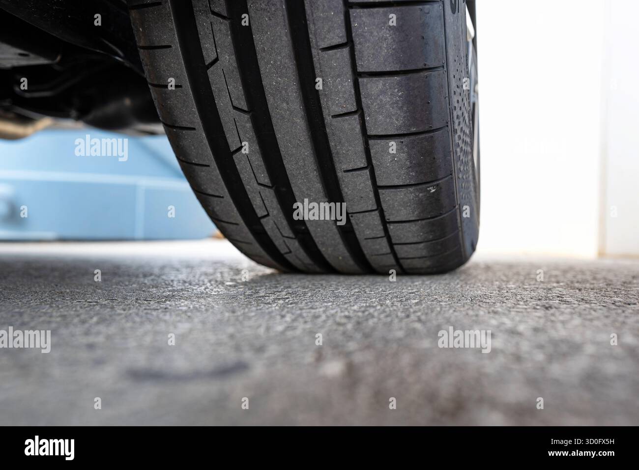 Profilo pneumatico e filettatura nuovi per auto. Basso, primo piano al livello del suolo, foto di dettaglio, niente persone Foto Stock