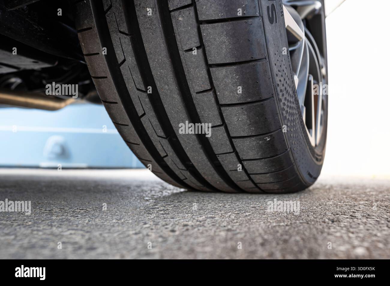 Profilo pneumatico e filettatura nuovi per auto. Basso, primo piano al livello del suolo, foto di dettaglio, niente persone Foto Stock