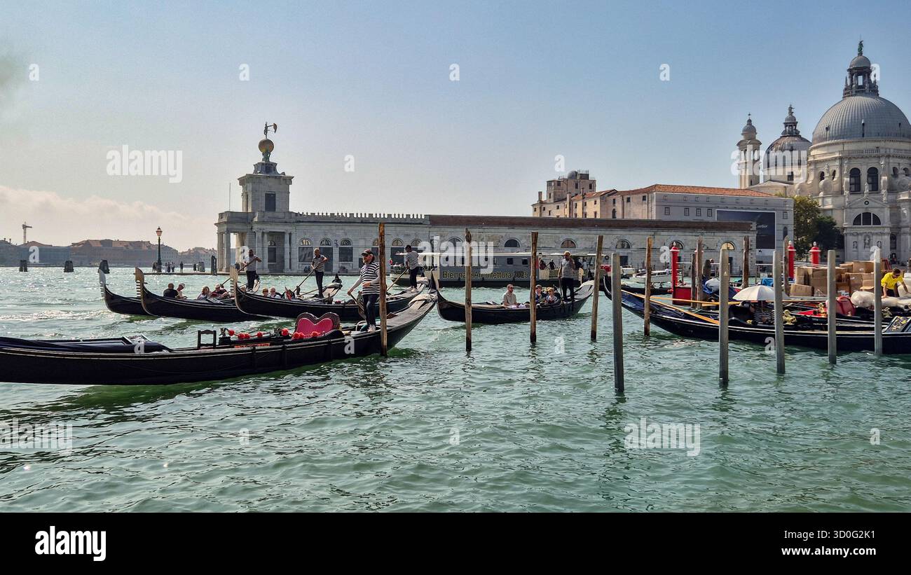 Gondole sul Canal grande con architettura storica e chiesa di Santa Maria della salute a Venezia, Italia. Foto Stock