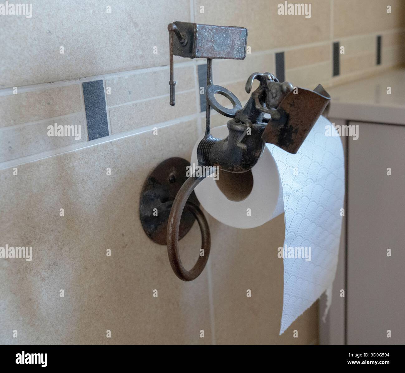 Portarotoli di carta igienica composto da un topo a cartoni in metallo seduto a leggere il giornale mentre era seduto sul suo gabinetto con il serbatoio sopra di lui. Foto Stock