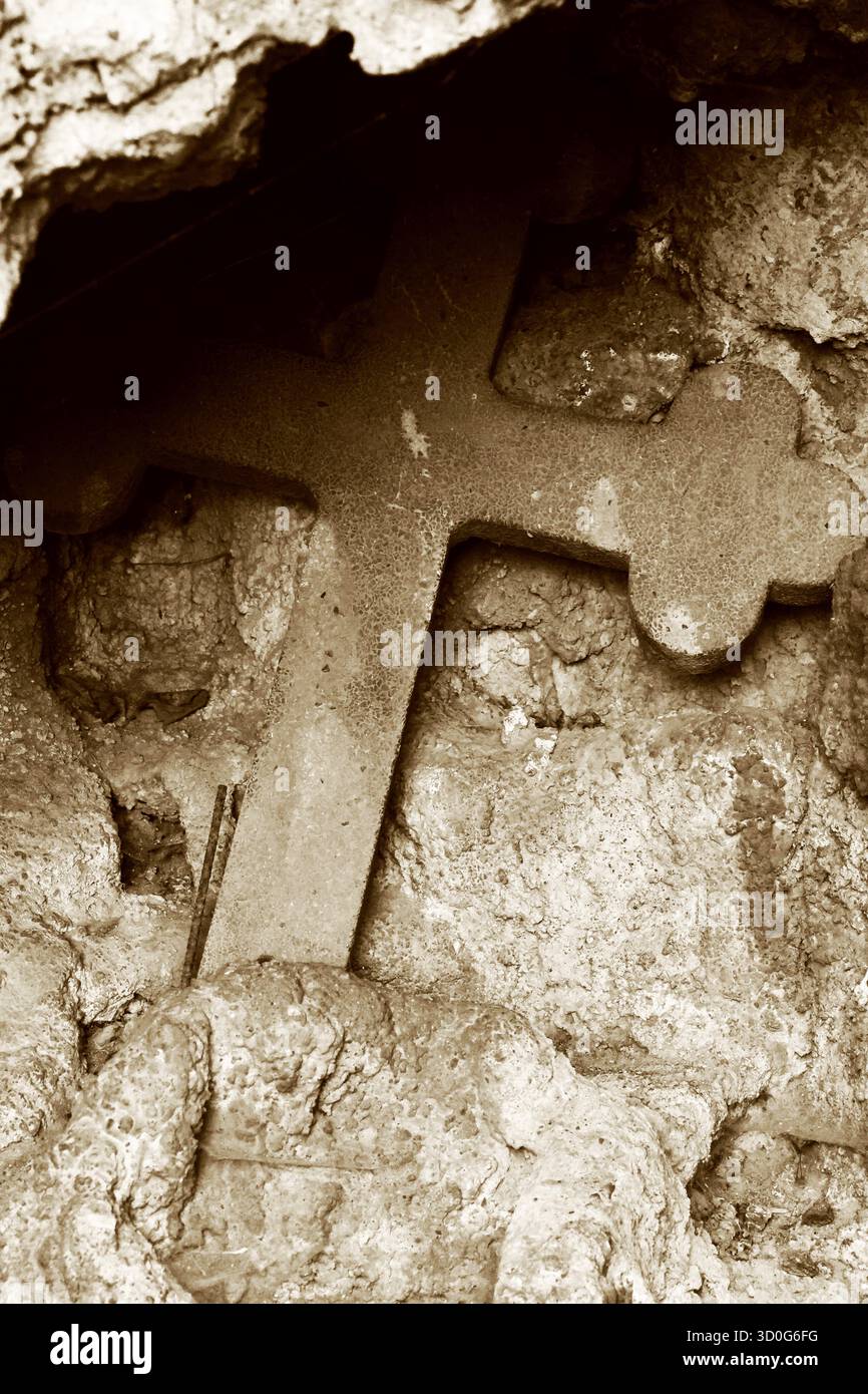 Antica Croce Santa di pietra in una nicchia rustica Foto Stock