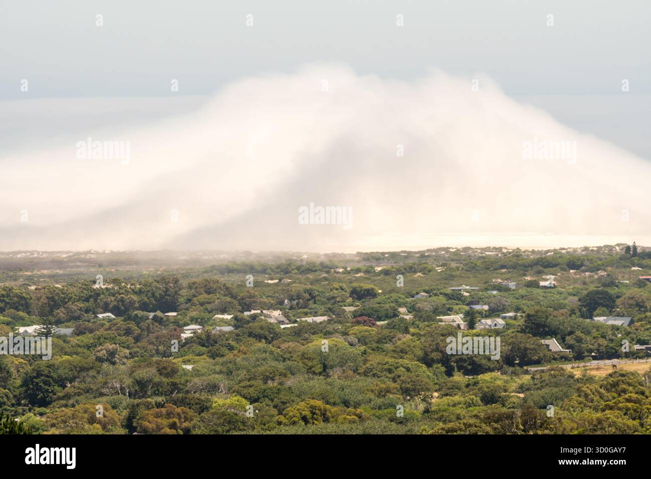 fronte freddo, fronte meteo, enorme nuvola di nebbia o nebbia che arriva sulla terra dall'oceano o dal mare, vista da lontano su un paesaggio verde Foto Stock