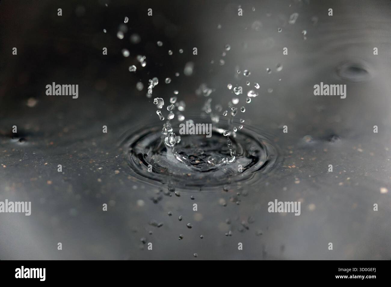 Scatto ad alta velocità di una goccia d'acqua che spruzza e crea una forma a corona Foto Stock