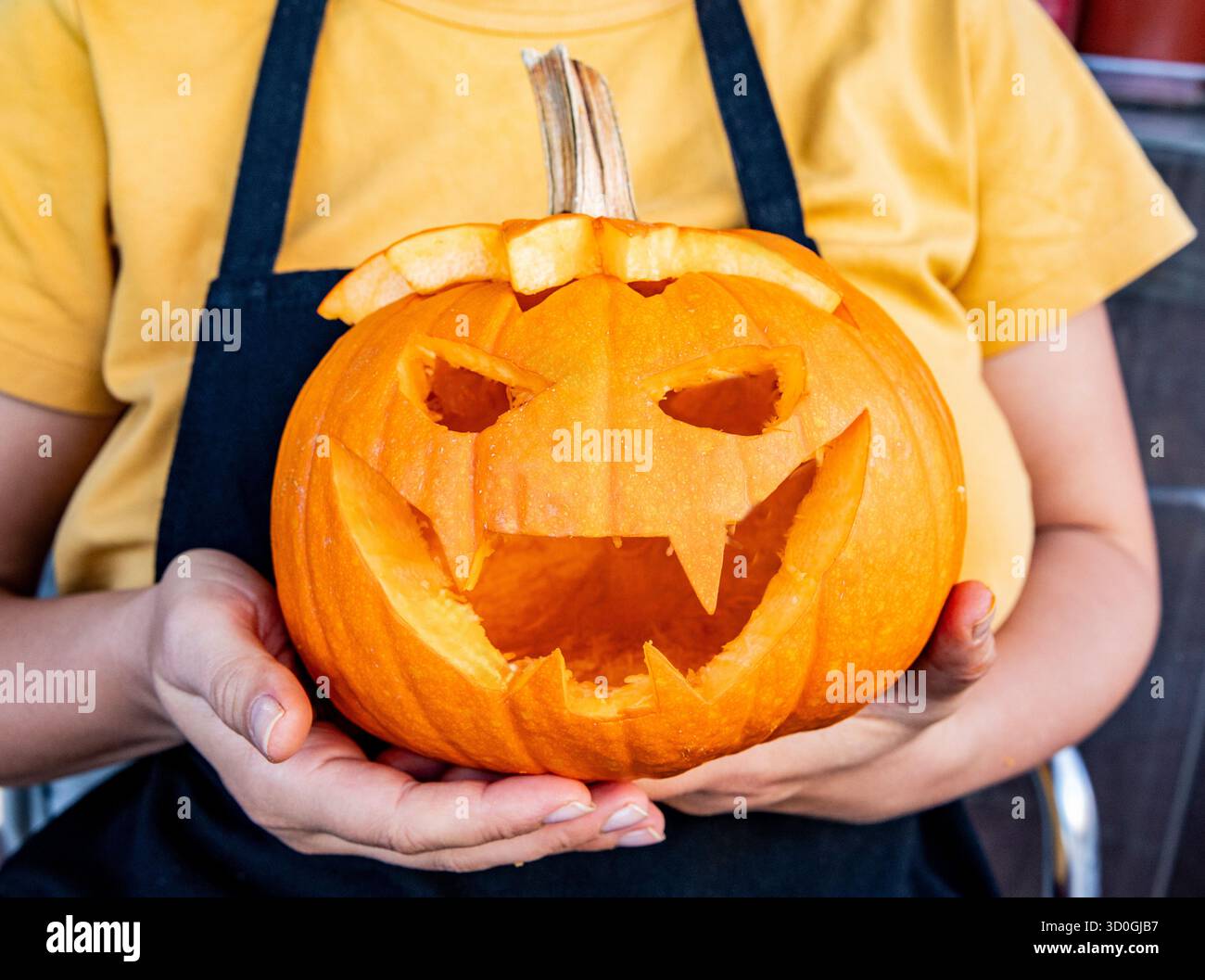 Decorazione di Halloween. Persona che tiene in mano la zucca fatta a mano con il jack o la lanterna. Fatto a mano Foto Stock