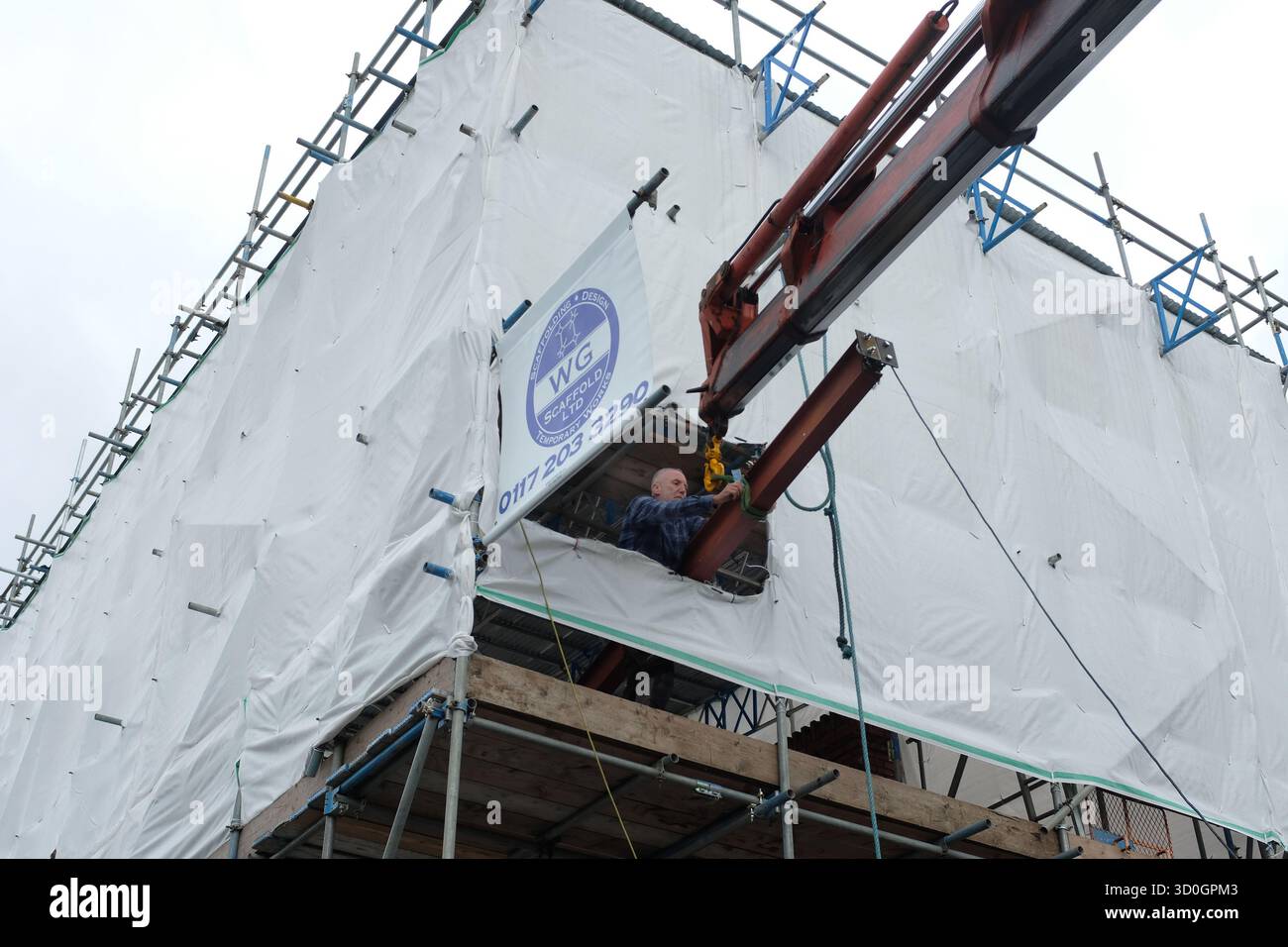 Una trave in acciaio che viene sollevata per un'estensione del loft su una casa. Foto Stock