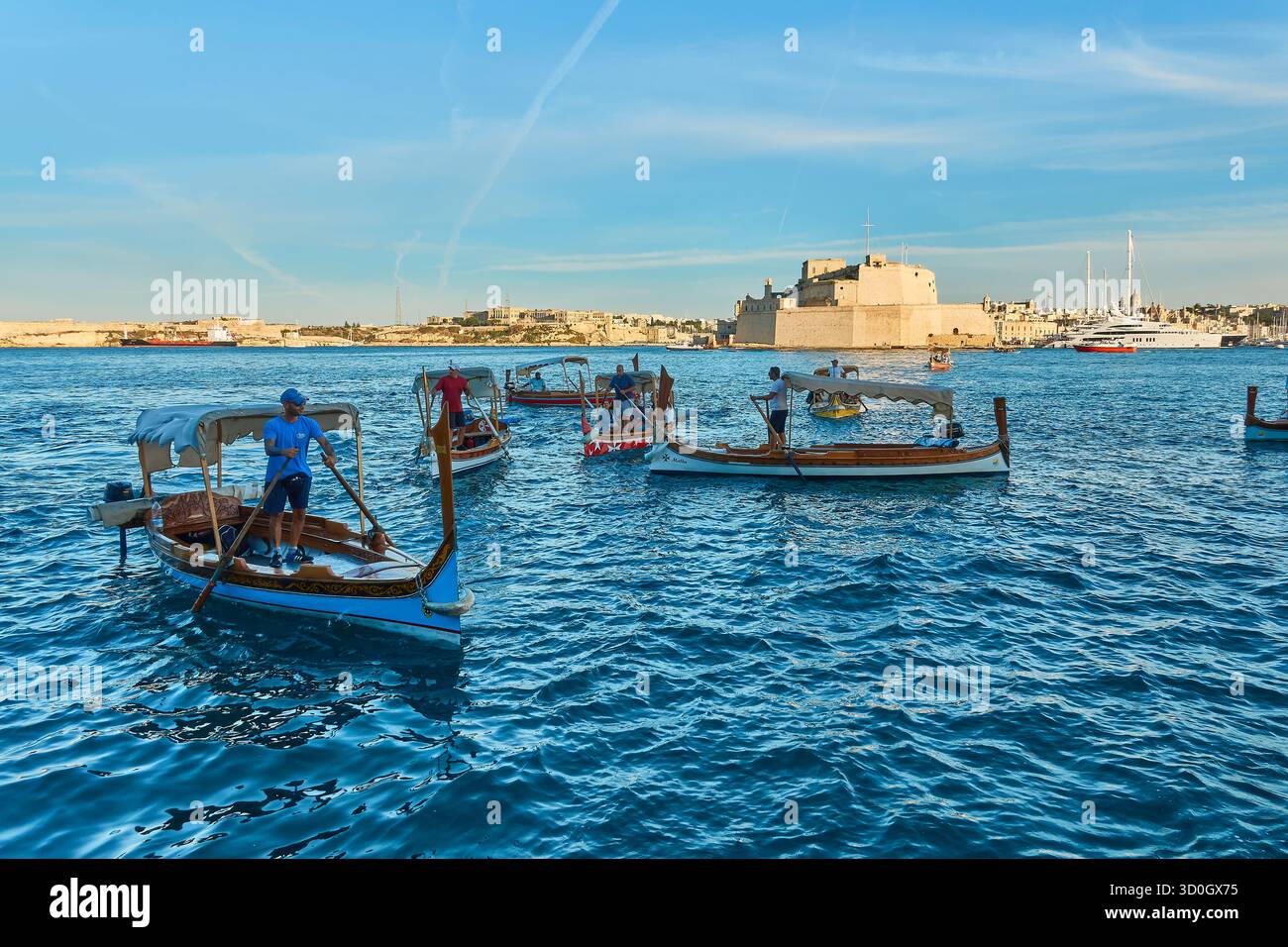 Luminose cabinovie maltesi e storico forte a la Valletta Malta con acqua blu e cielo soleggiato Foto Stock