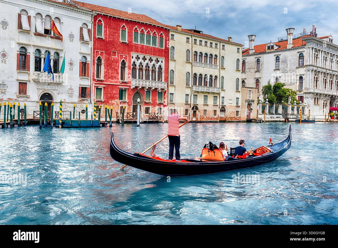 Persone non identificate su un tradizionale Gondola con architettura paesaggistica lungo il Canal Grande nel sestiere di Cannaregio a Venezia, Italia Foto Stock