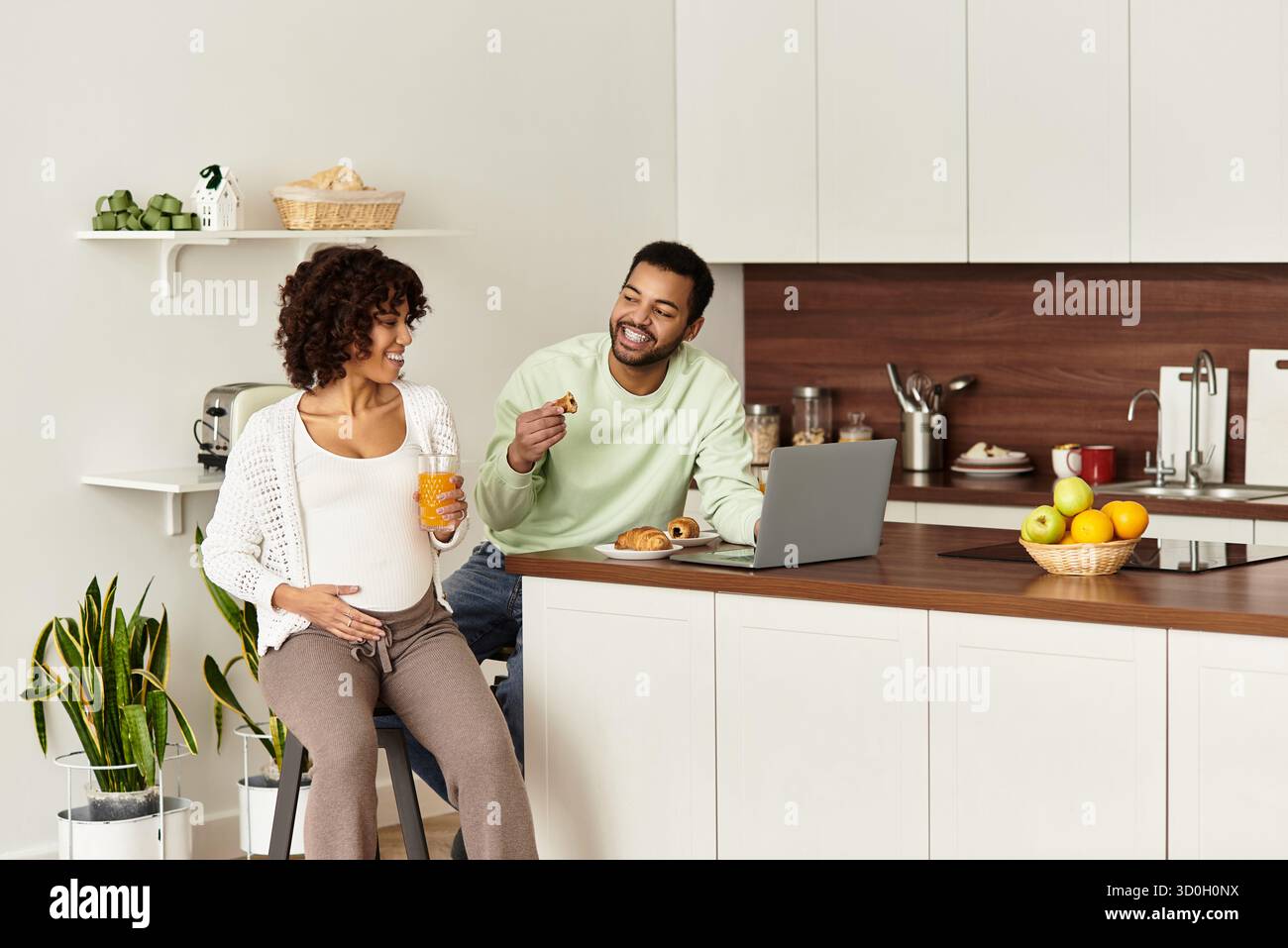 La coppia si gode una mattinata accogliente insieme, celebrando la loro prossima aggiunta alla famiglia. Foto Stock