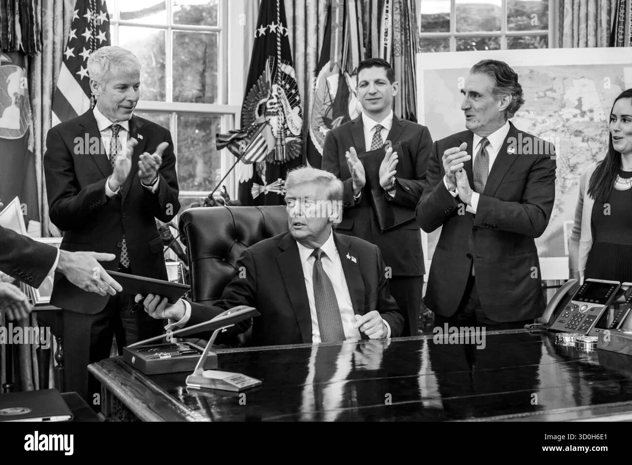 Il presidente Donald Trump consegna l'ordine esecutivo firmato che approva il progetto Ambler Road come applaudito dei funzionari dell'amministrazione durante la cerimonia dell'Ufficio ovale. 6 ottobre 2025. Washington, D.C. immagine gentilmente concessa dalla Casa Bianca. Foto Stock