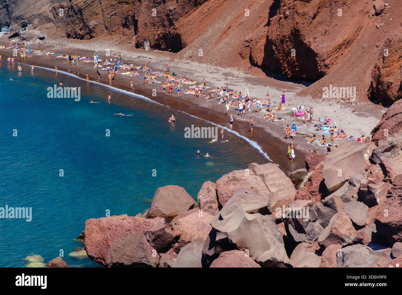 Santorini, GR - 4 settembre 2025: Molti turisti si godono il sole sulla famosa spiaggia rossa di Santorini Foto Stock