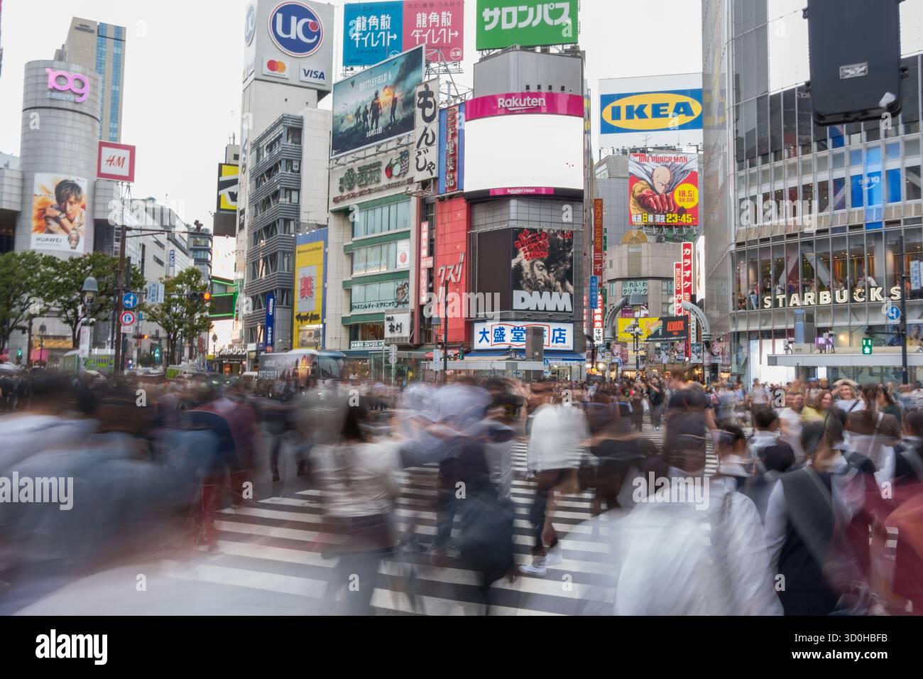 Tokyo, Giappone - 1 ottobre 2025: Vista dell'iconico incrocio di Shibuya, animato da una sfocatura di pedoni sotto un vivace arazzo di torreggianti cartelloni pubblicitari. Foto Stock