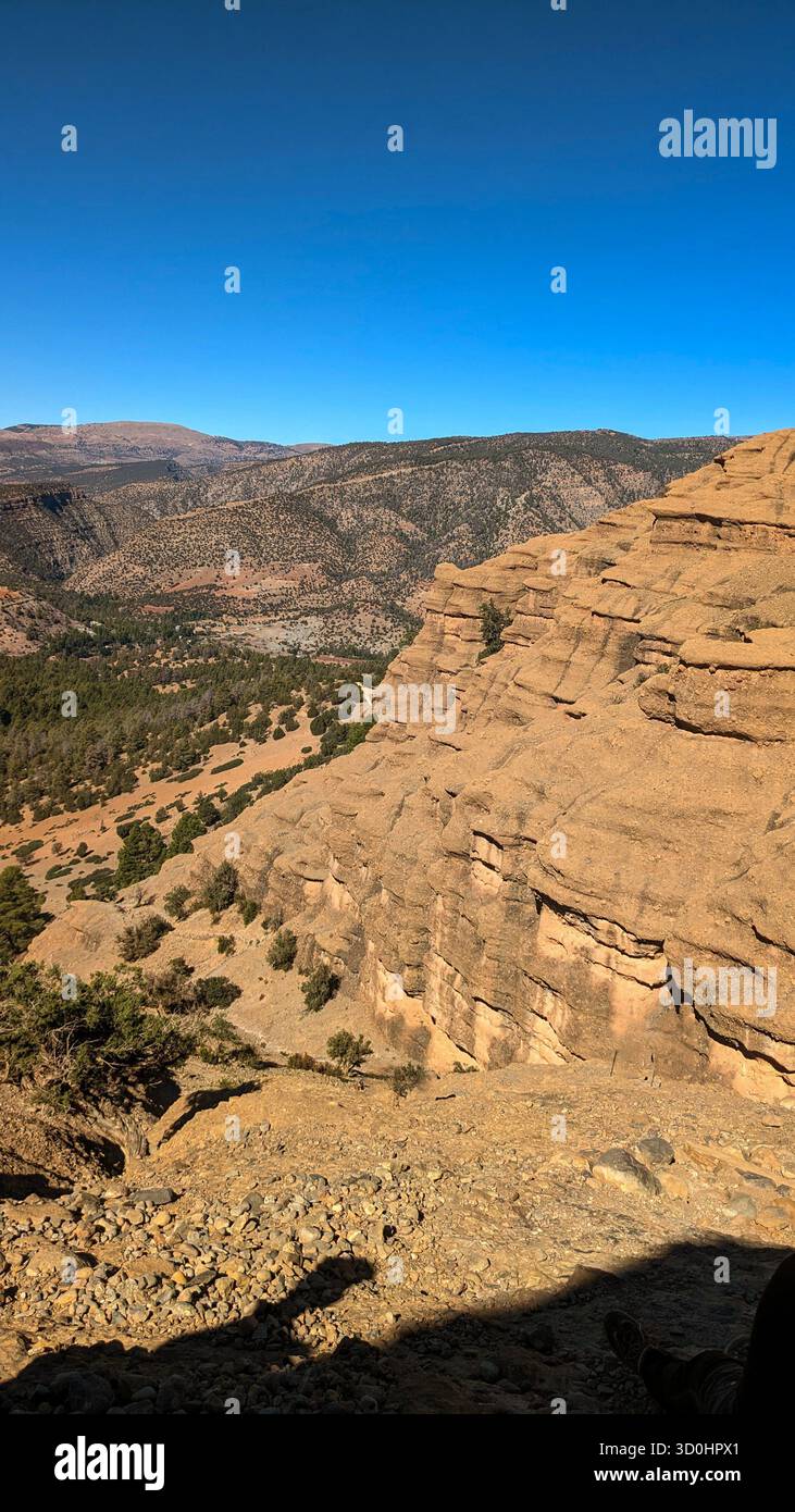 Vista panoramica ad alto angolo di una vasta scogliera di arenaria e valle sotto un cielo azzurro luminoso, che mostra scala, colore e solitudine Foto Stock