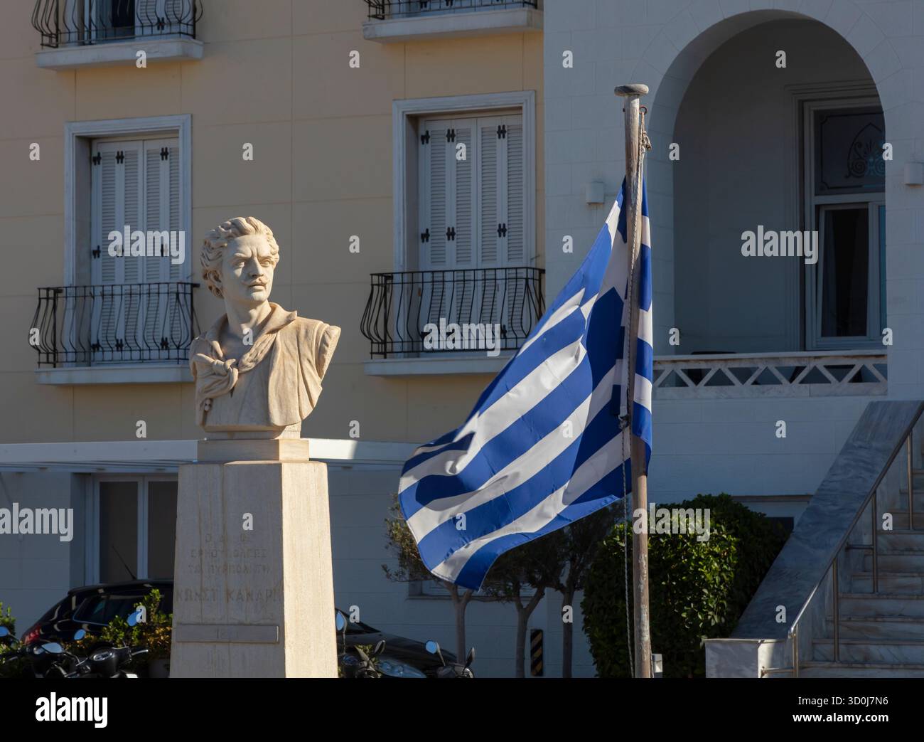 Bandiera greca e busto in marmo del padre della città nella città di Ermoupoli - Isola di Syros, Isole Cicladi, Grecia Foto Stock
