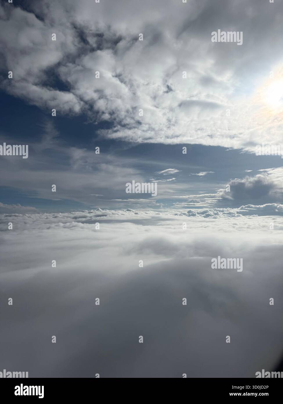 Perduto nell'abbraccio delle nuvole, dove il cielo incontra il cielo in una danza di eterea bellezza. Sopra il mondo, una tela di blu e billo senza fine Foto Stock