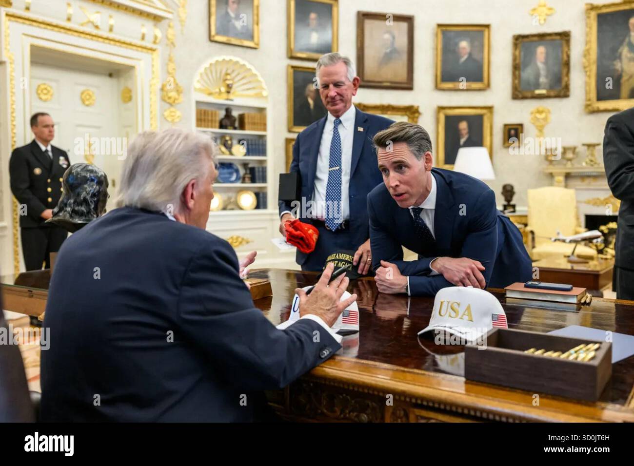 Il presidente Donald Trump parla con i senatori Tommy Tuberville e Josh Hawley nell'ufficio ovale durante le discussioni successive al pranzo al Rose Garden Club. Washington, D.C. 21 ottobre 2025. Per gentile concessione della Casa Bianca. Foto Stock