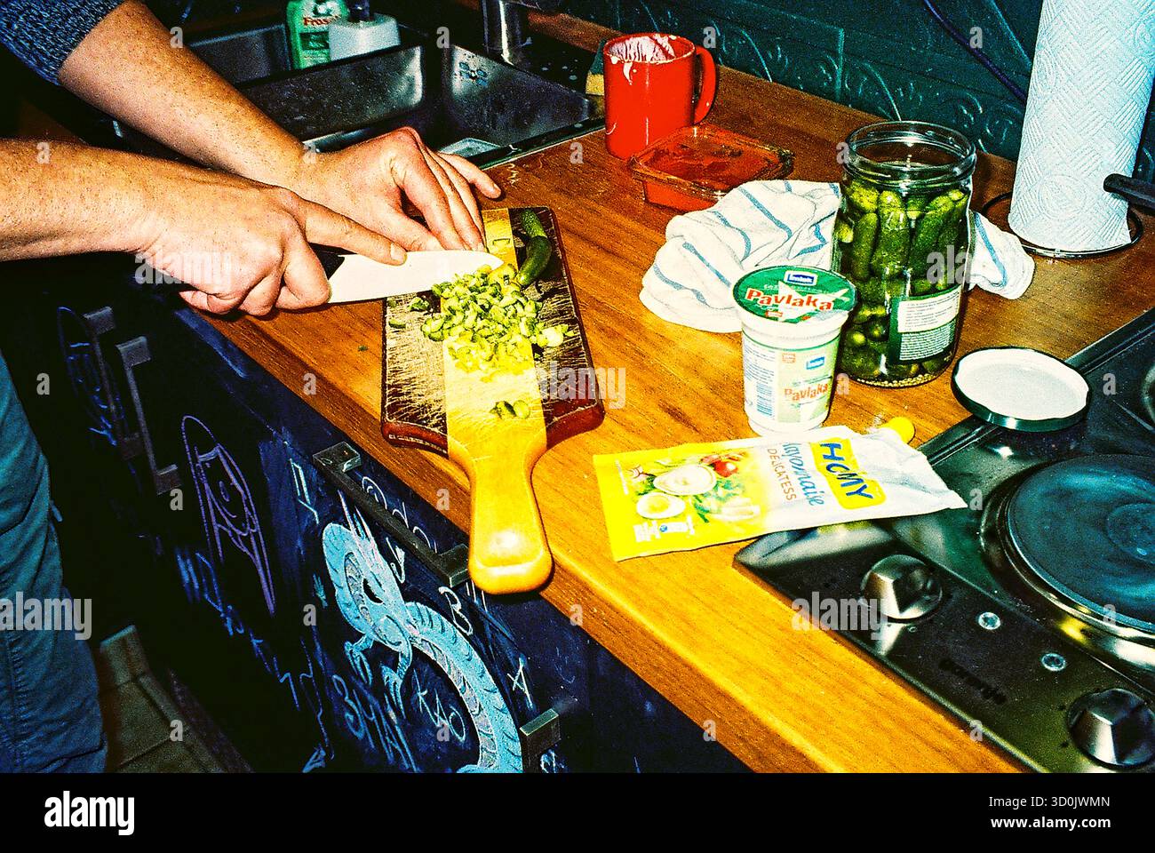 Preparare la salsa su un ripiano della cucina con ingredienti e utensili disposti, catturati in un momento di cottura naturale. Foto Stock