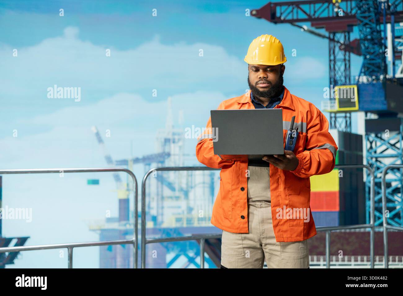 Il dipendente della piattaforma offshore supervisiona le operazioni del ponte con un laptop, garantendo la conformità ai protocolli di sicurezza. Tecnico che esegue la manutenzione preventiva su macchinari critici per carri di perforazione Foto Stock
