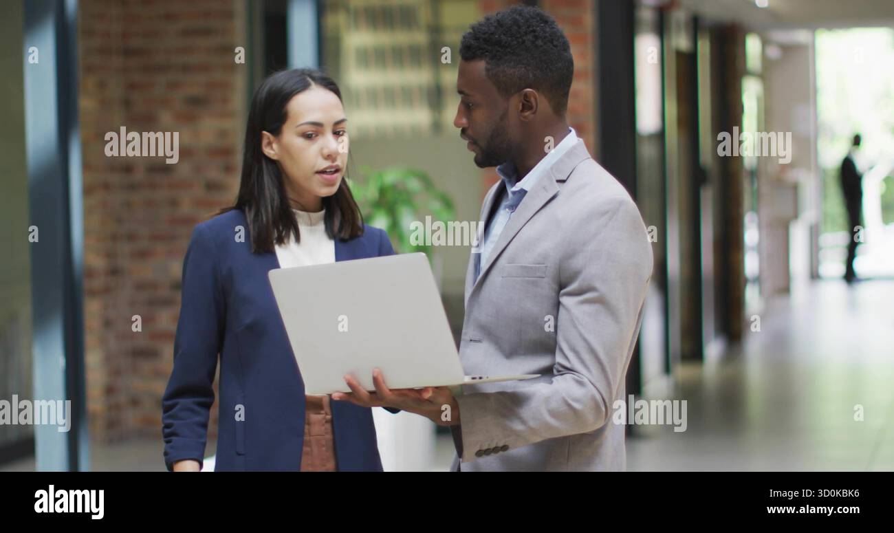 Colleghi di lavoro che collaborano in abiti da ufficio, con tablet e notebook color argento Foto Stock